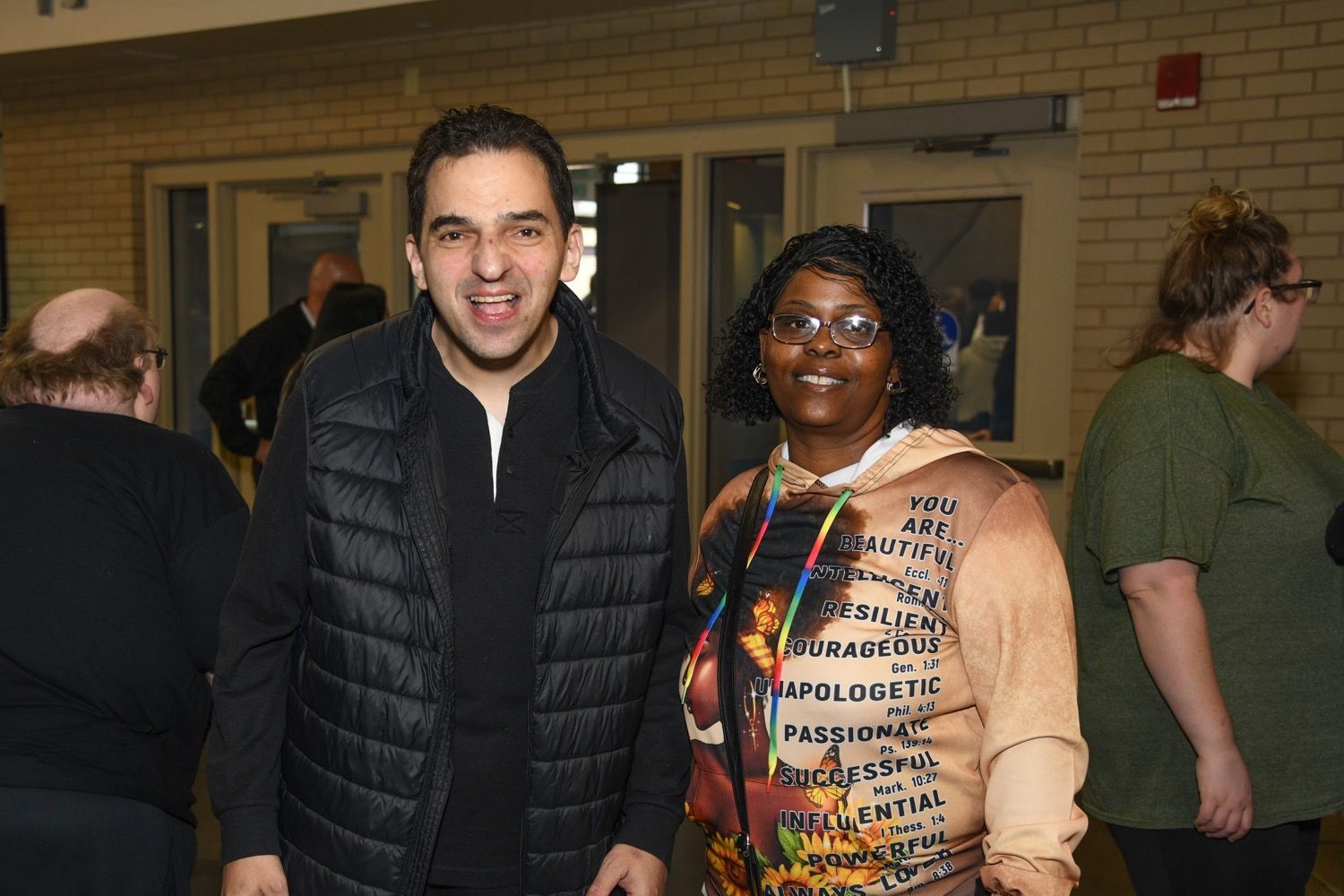 a group of baseball players and mascots are standing on a baseball field in front of a crowd .
