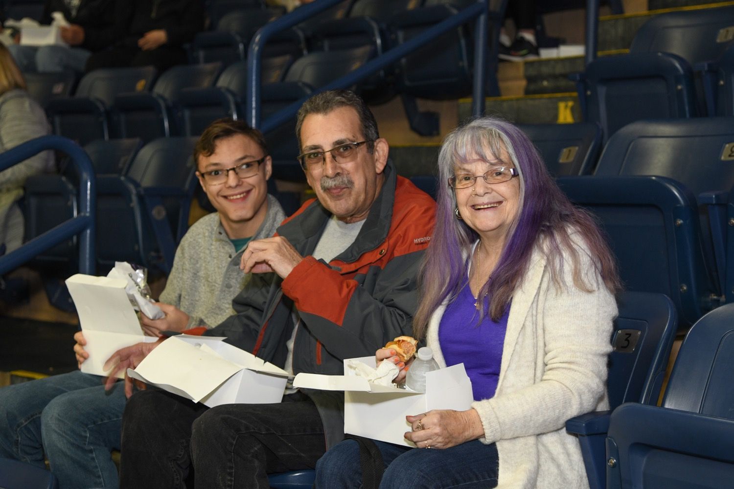 a group of people are standing on a baseball field .