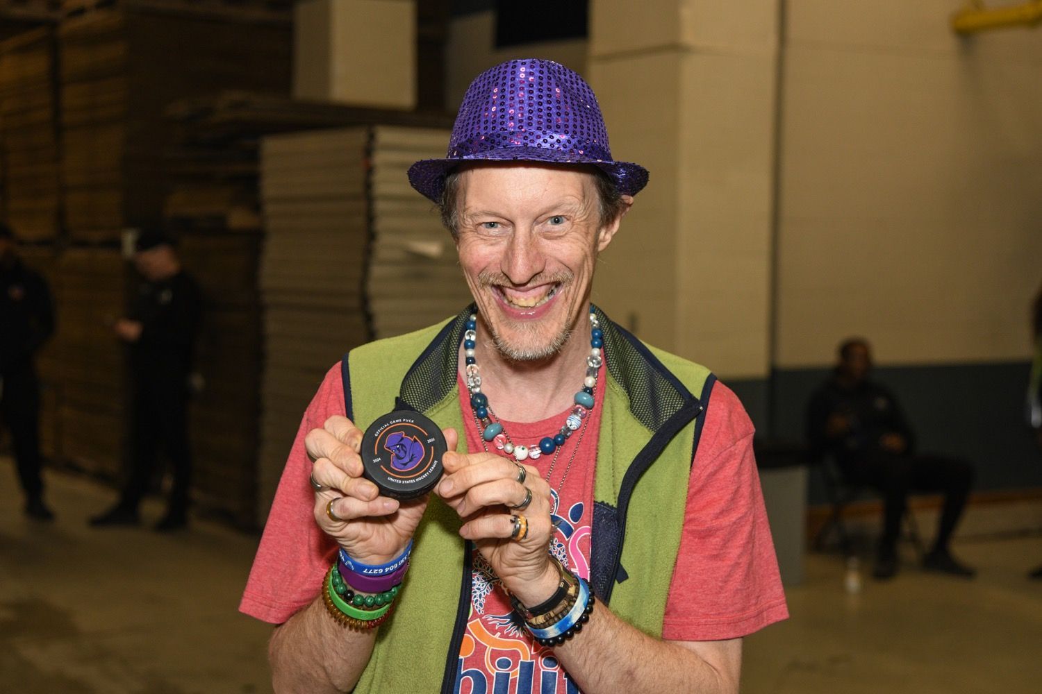 three women are standing on a baseball field holding jerseys .