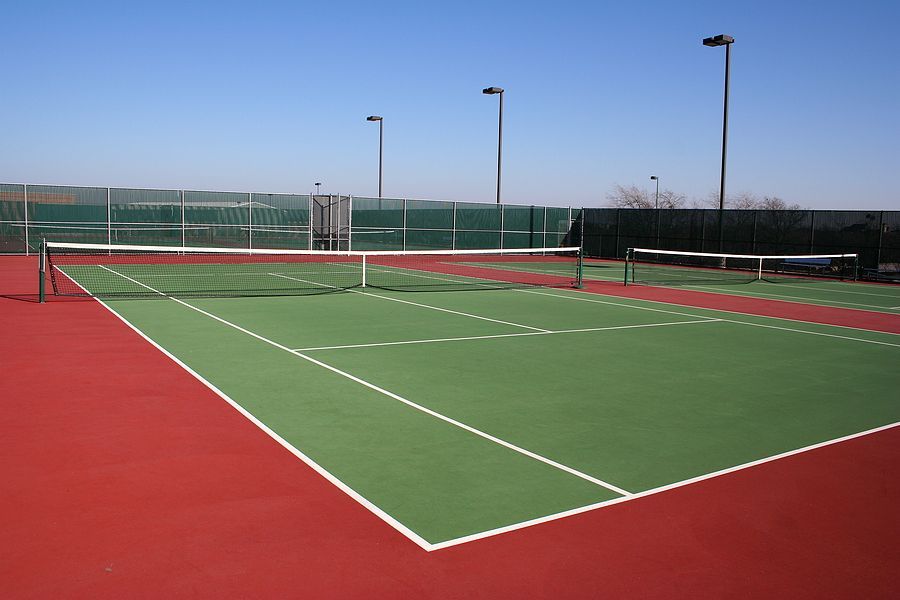 A green and red tennis court with a white line