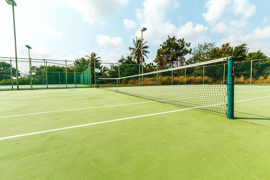 An empty tennis court with a green net