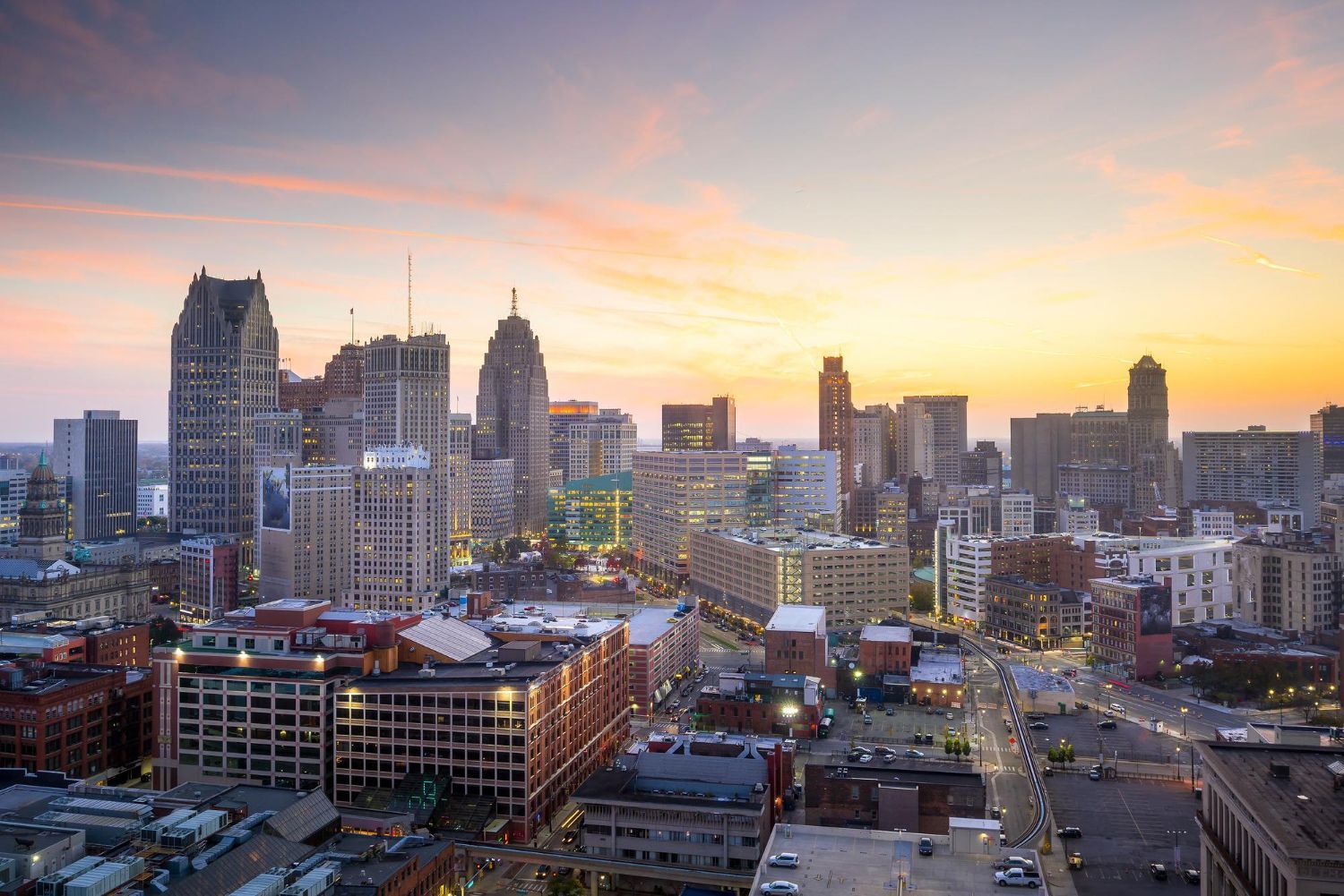 Detroit skyline with the Renaissance Center at sunset, reflecting over the Detroit River.