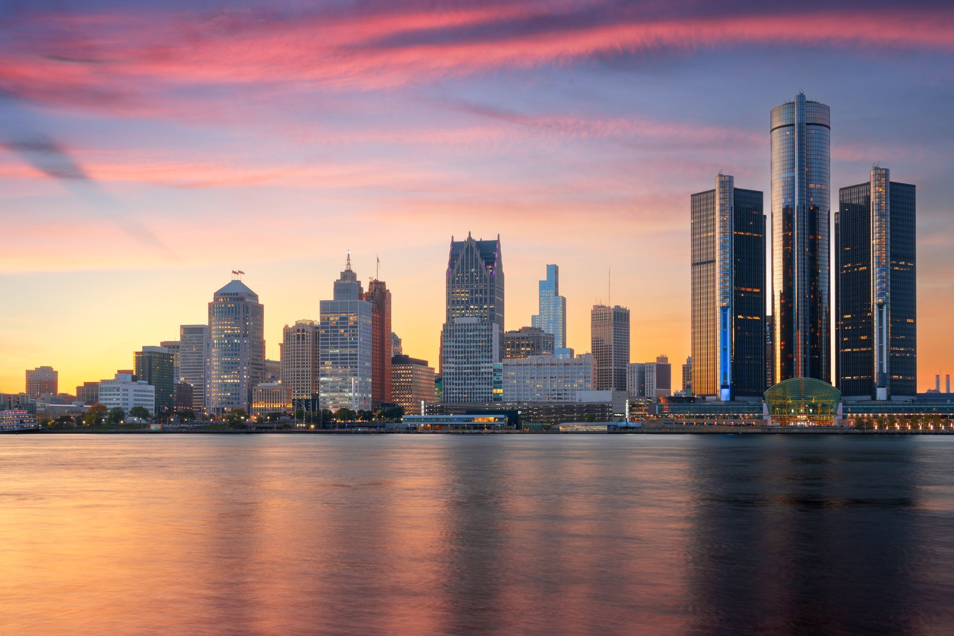 Detroit skyline with the Renaissance Center at sunset, reflecting over the Detroit River.