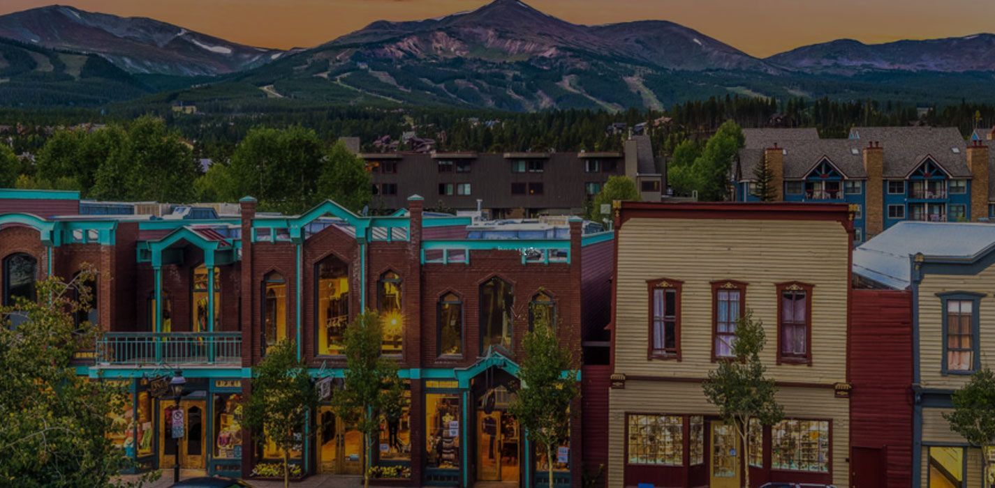 a row of buildings in Breckenridge colorado with mountains in the background