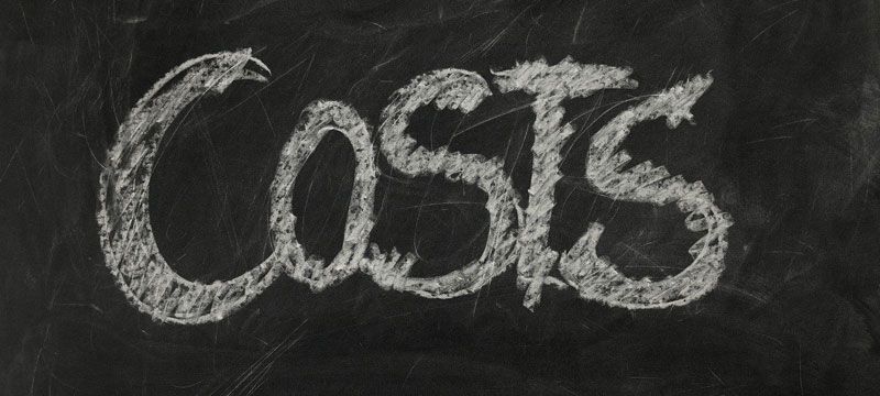 the word costs is written in white chalk on a blackboard