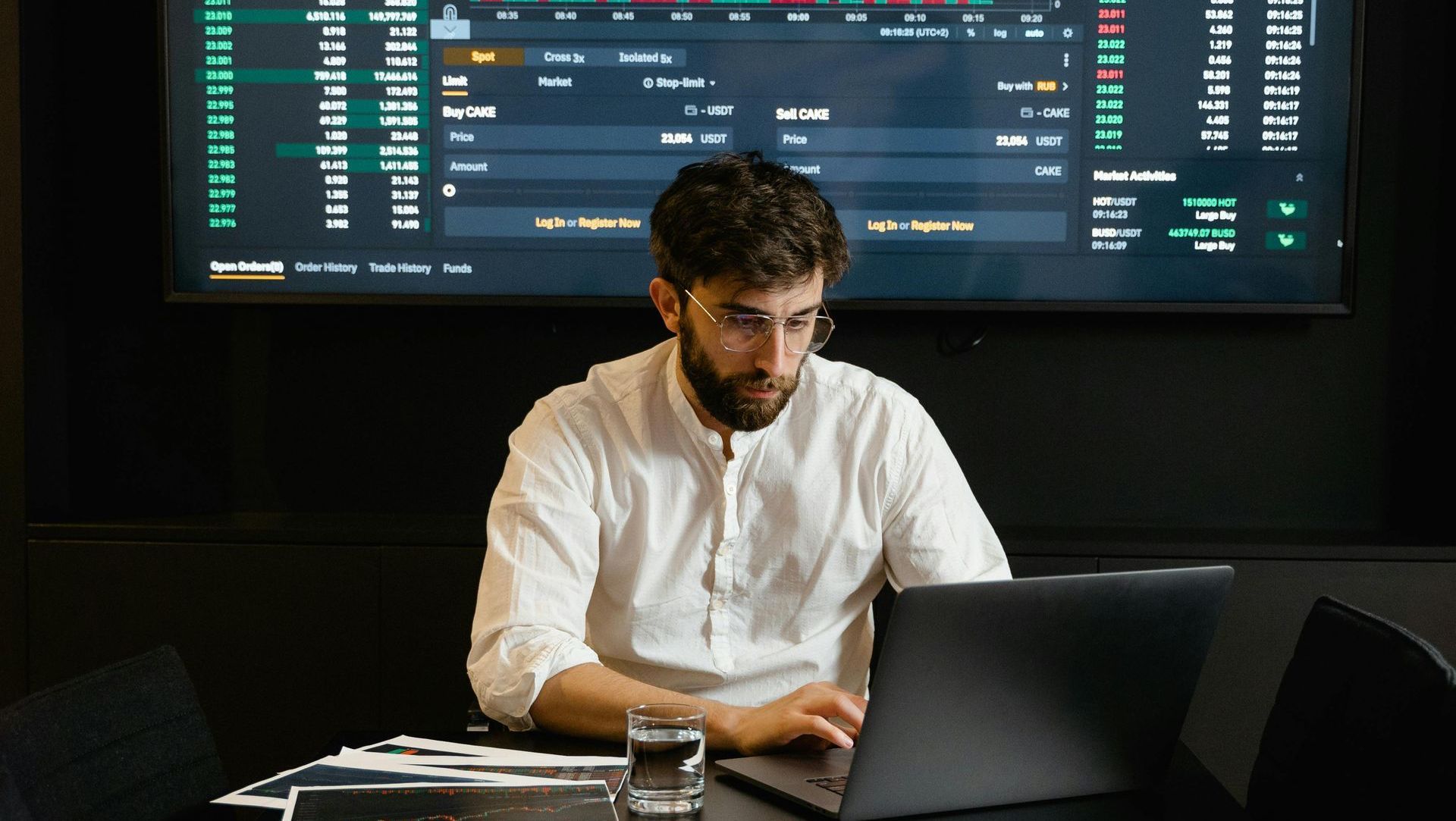A man is sitting at a desk using a laptop computer.
