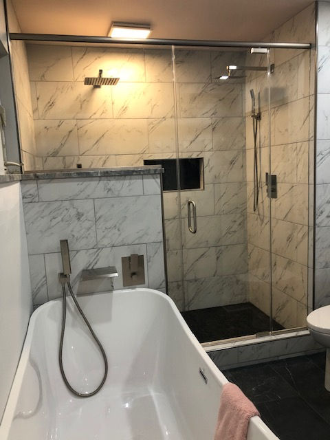 A bathroom with a bathtub and a walk in shower