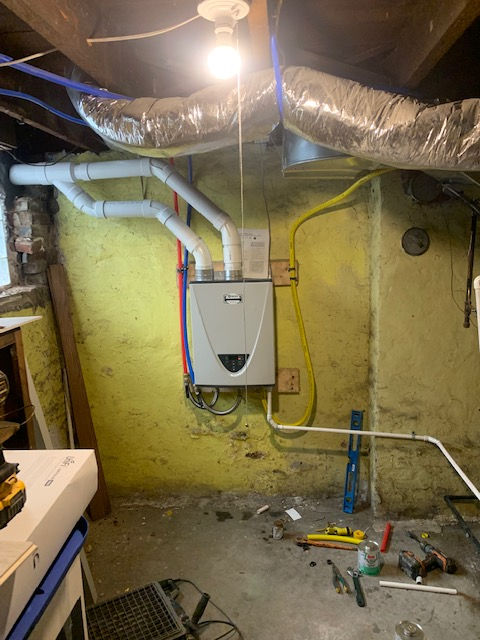 A boiler is being installed in a basement in a house.