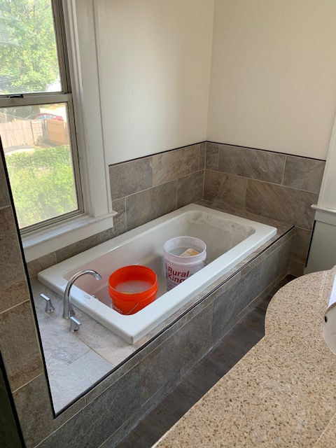 A bathtub with a bucket of soap in it