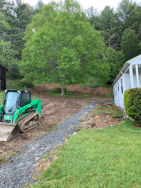 A green bulldozer is parked in front of a house.