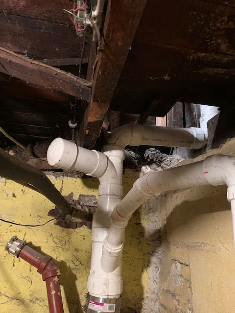 A bunch of pipes are connected to each other in a basement.