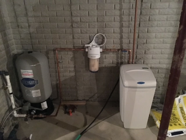 A water heater and a water softener in a basement