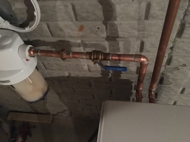A copper pipe with a blue valve attached to it