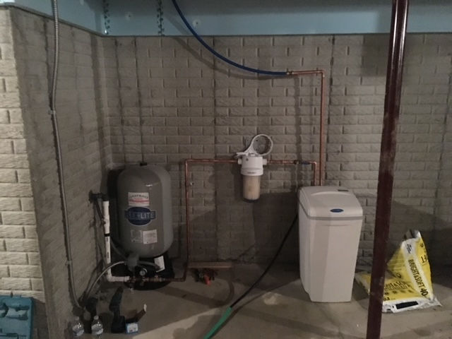 A basement with a water tank and a water softener