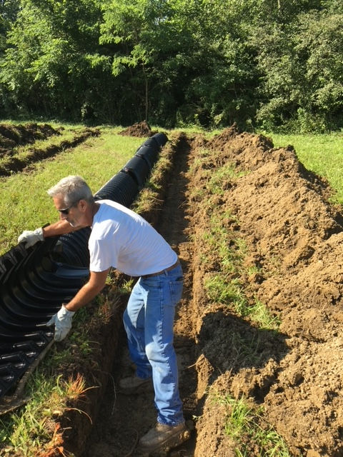 A man is digging in the dirt in a field