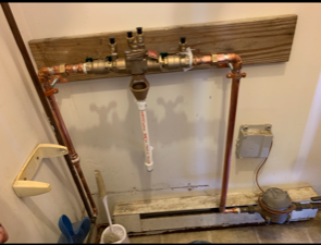A picture of a bathroom with a faucet and pipes.