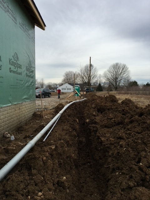 A large hole in the ground with a white pipe in it