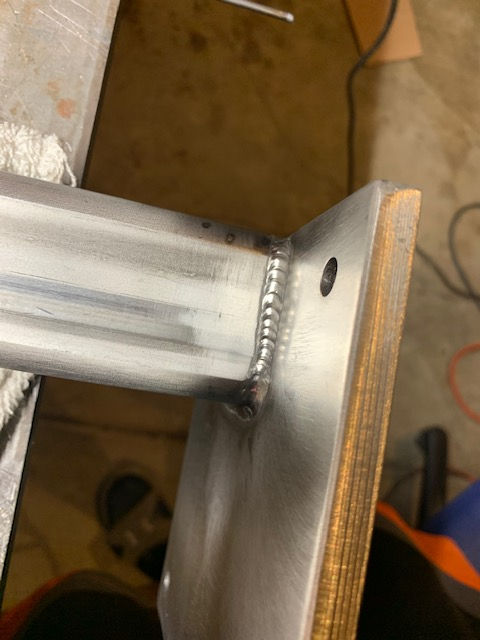 A piece of metal is sitting on top of a wooden table.