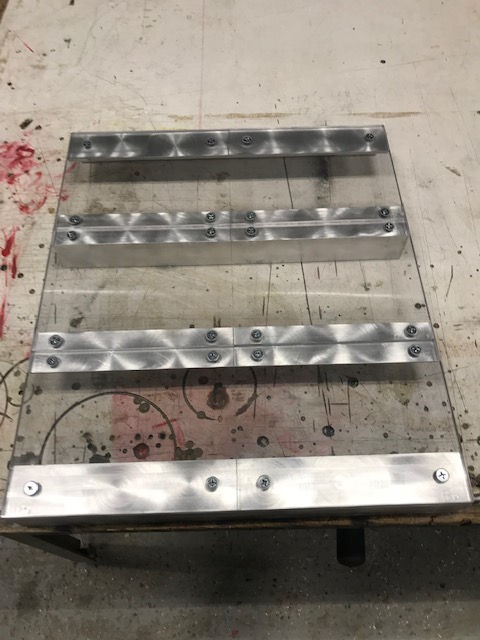 A piece of metal is sitting on top of a wooden table.