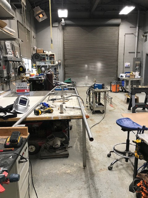 A workshop with a lot of tools and a table with a pipe on it.