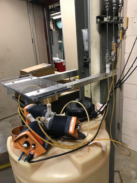 A machine is sitting on top of a large tank in a room.