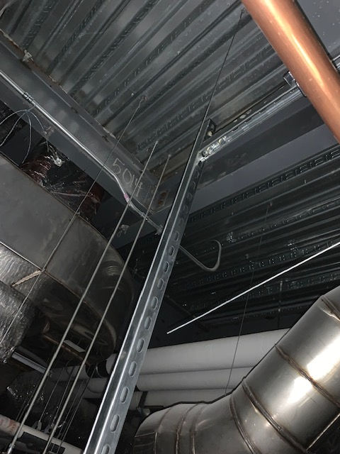 A copper pipe is hanging from the ceiling of a building