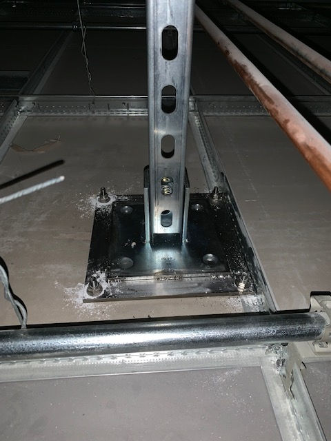 A metal pole is sitting on top of a concrete floor.