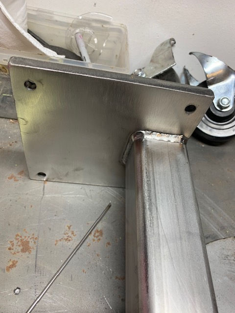 A piece of metal with wheels on it is sitting on a table.