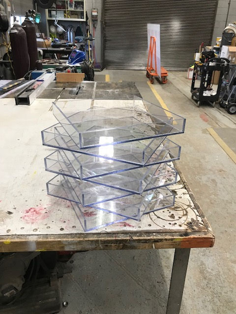A stack of clear plastic trays sitting on top of a table.