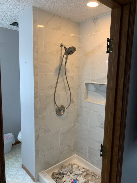 A bathroom with a walk in shower and a toilet.