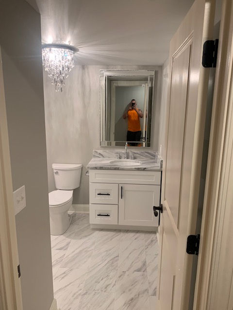 A bathroom with a sink , toilet and mirror.