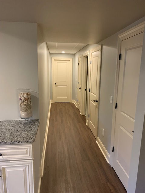 A long hallway with wooden floors and white doors