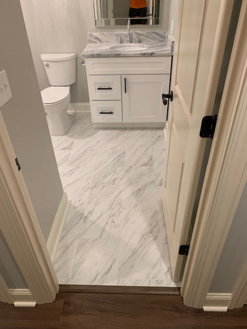 A bathroom with a sink , toilet and mirror.