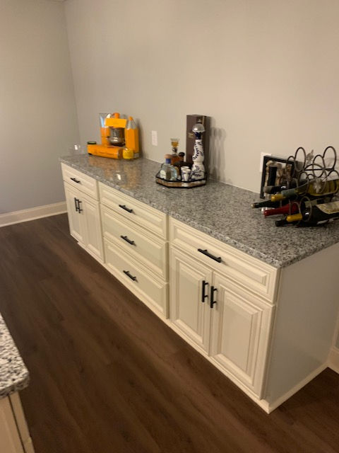 A kitchen with white cabinets and granite counter tops