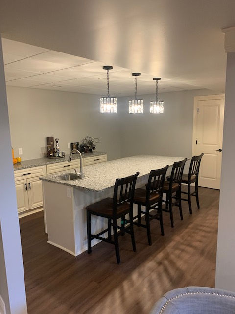 A kitchen with a large island and chairs