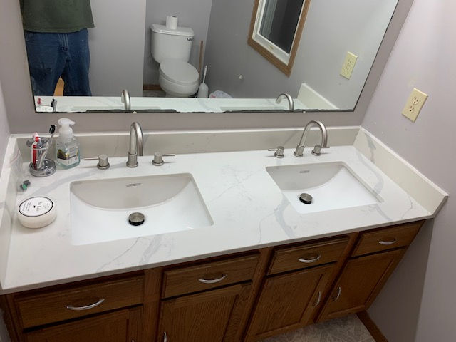 A bathroom with two sinks and a toilet