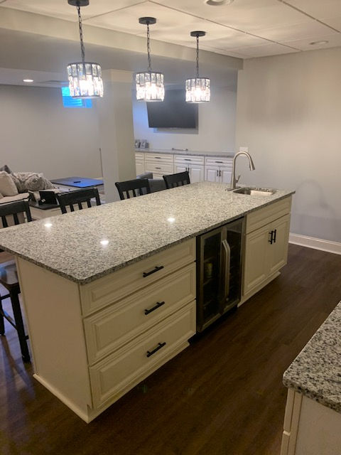 A kitchen with a large island and white cabinets