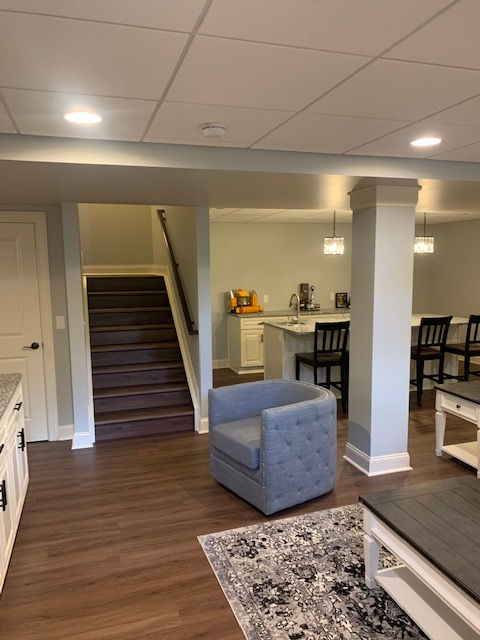 A living room with a chair and stairs in the background
