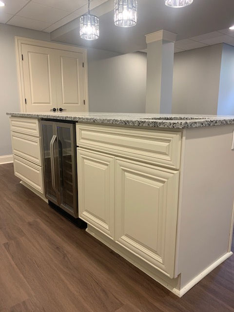 A kitchen with white cabinets and a stainless steel refrigerator.