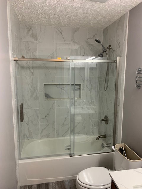 A bathroom with a bathtub , toilet , sink and shower.