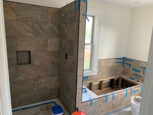 A bathroom under construction with a tub and shower.