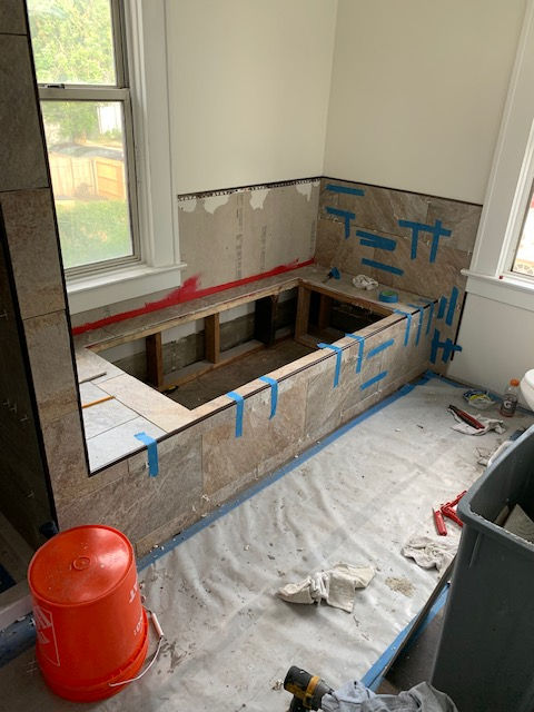 A bathtub is being built in a bathroom.