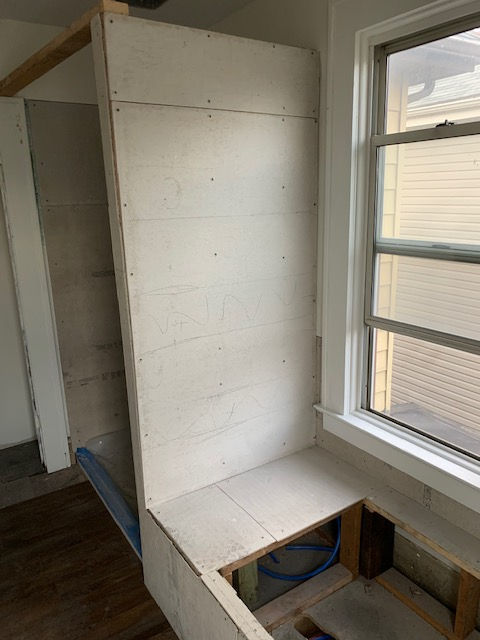A bench is being built in a room next to a window.