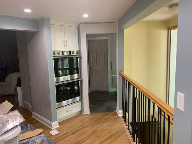 A kitchen with a staircase leading to the second floor