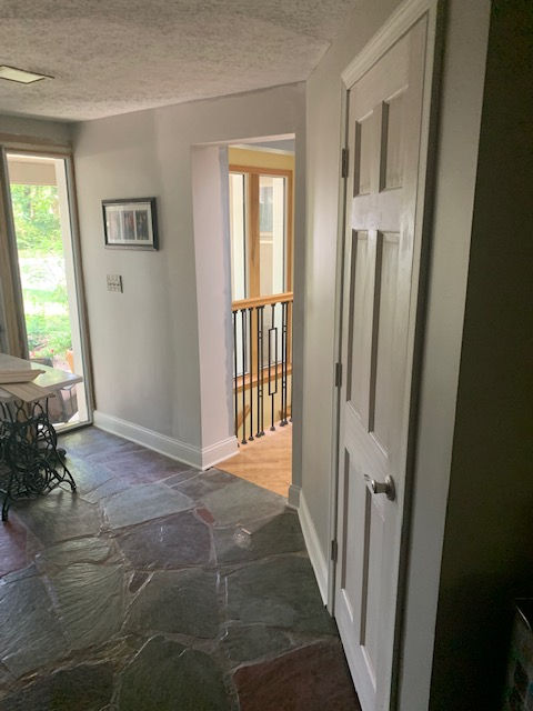 A hallway with a sliding glass door leading to a staircase.