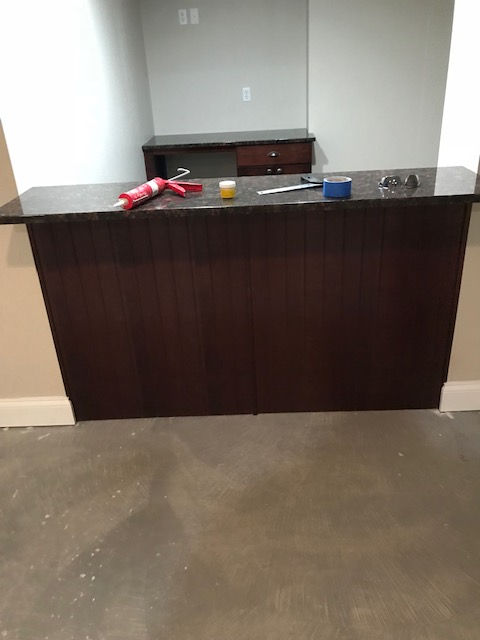 A large wooden counter in a room with a concrete floor.