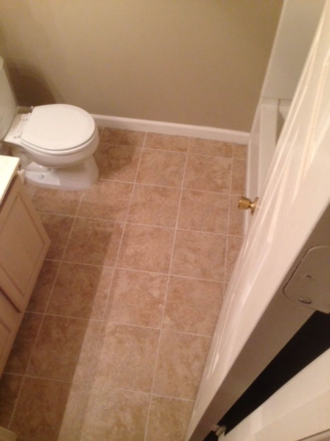 A bathroom with tile floors and a toilet