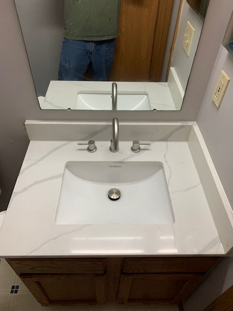 A bathroom sink with a faucet and a mirror