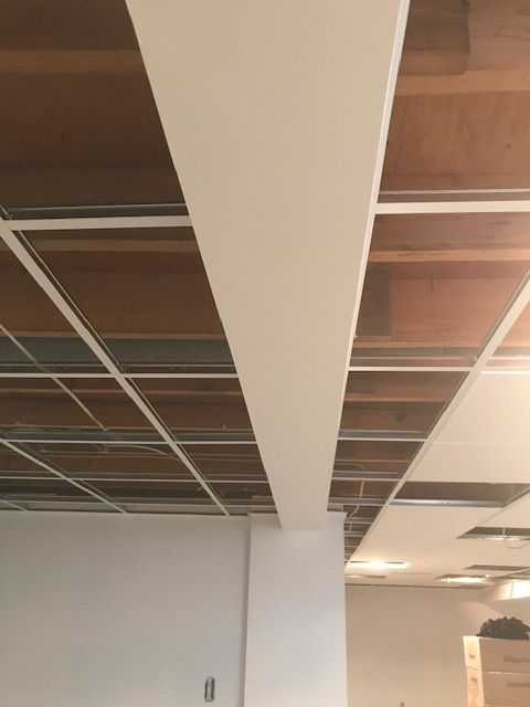 A room with a wooden ceiling and a white wall.