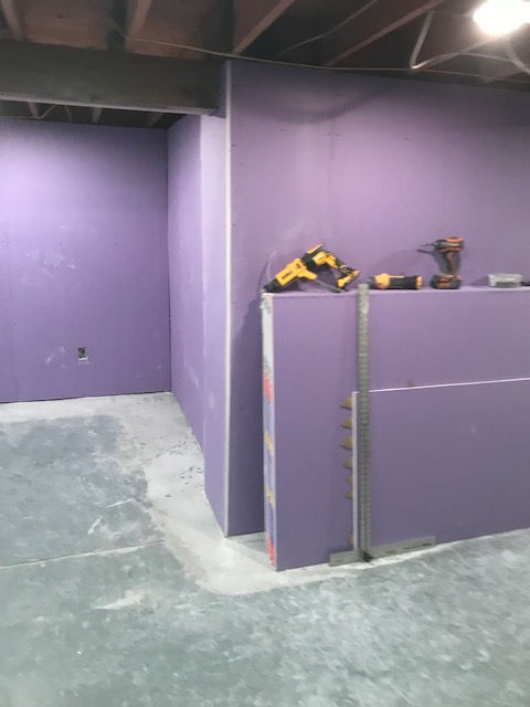 A room with purple walls and a concrete floor